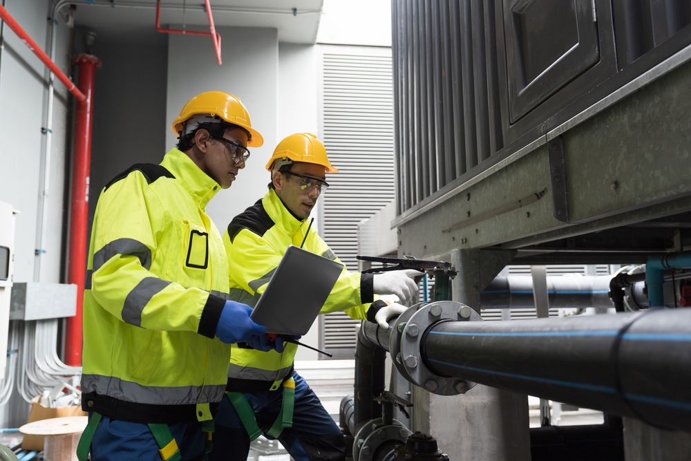 Facility management team members repairing industrial equipment