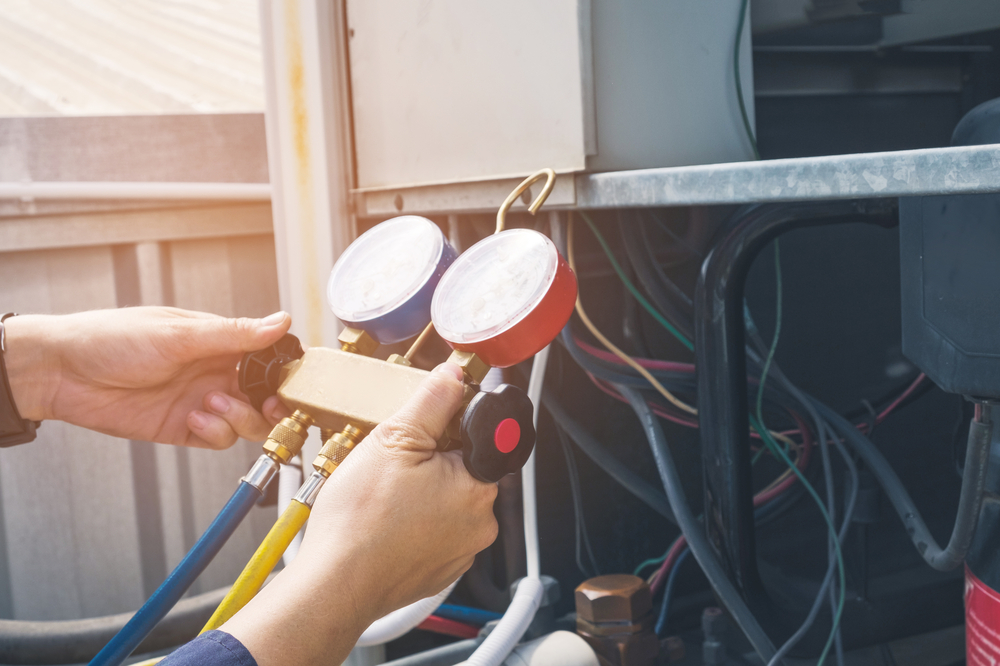 HVAC maintenance technician checking an air conditioner