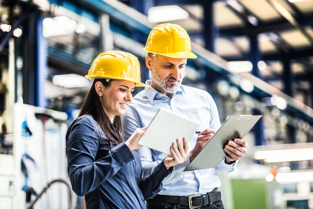 Facilities management project managers reviewing tablet and clipboard
