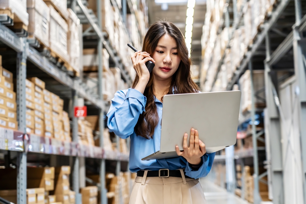 A facility manager in a warehouse on the phone with a vendor