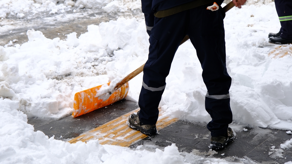 Industrial maintenance worker shoveling snow